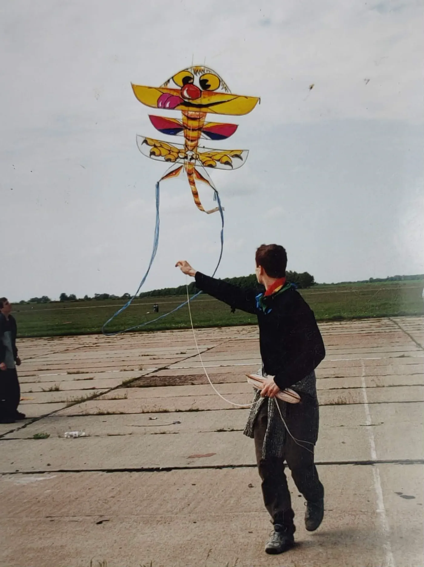 Un joven lanzando una cometa-criatura pintada a mano